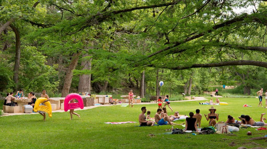 A couple standing on the summit of Old Baldy Park at sunset, overlooking the rolling hills of the Texas Hill Country, showcasing romantic things to do in Wimberley, TX.